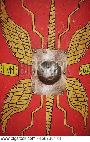 Red Vintage Shield Of An Ancient Roman Warrior. Reconstruction Of Military Events During The War Of 