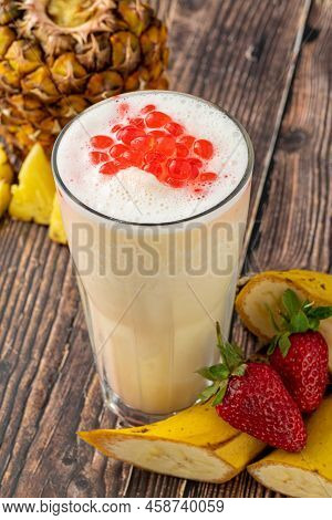 Banana, Strawberry And Pineapple Smoothie On Wooden Table And Bubble Tea Or Boba Tea Balls On It