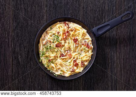 Capunti Pasta In Cream Pecorino Cheese And Pancetta Sauce On Skillet On Dark Wooden Table, Horizonta