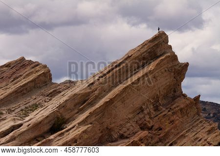 Agua Dulce, Ca - March 11 2021:  A Lone Person Stands Atop Vasquez Rocks Under Dramatic Clouds