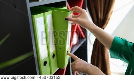 Close-up Of Woman Hands Taking Off Green Paper Folder. Archive, Paperwork And Office Work Business A