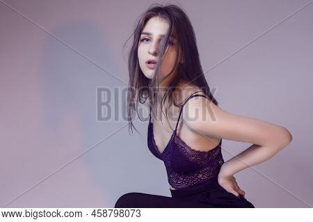 Winsome Seductive Woman Posing In Vilet Lingerie And Pants Showing Sporty Body On Gray Background