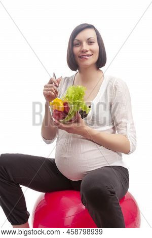 Pregnancy Ideas. Portrait Of One Caucasian Brunette Woman In White Clothing Sitting On Big Fitball W