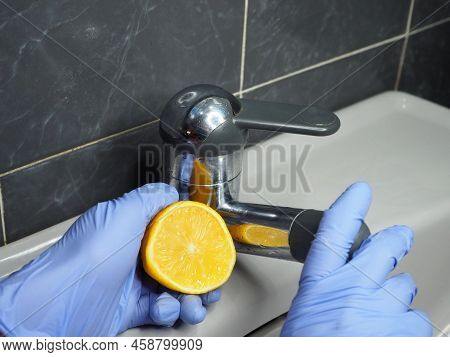 Removing Scale From Chrome Surfaces With Lemon Juice. Close-up Of A Gloved Hand, Halves Of A Lemon, 