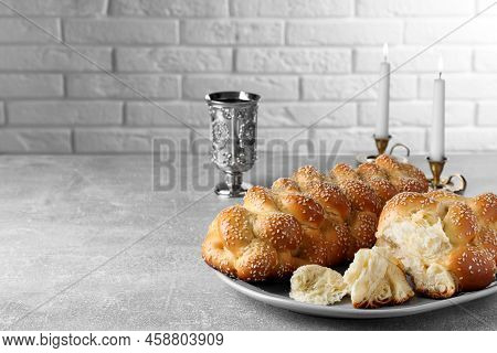 Homemade Braided Bread With Sesame Seeds And Goblet On Grey Table, Space For Text. Traditional Shabb