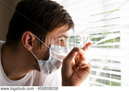 Young Man In The Surgical Mask Looking In The Window