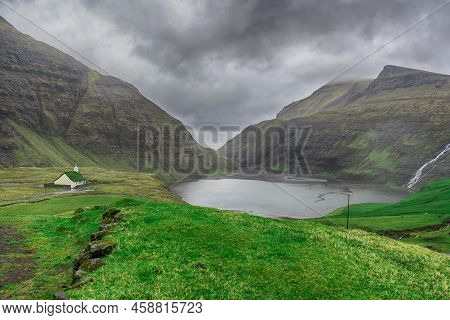 Beautiful Little Church, With A Grassy Roof, Against The Backdrop Of Beautiful Mountains, And Dramat