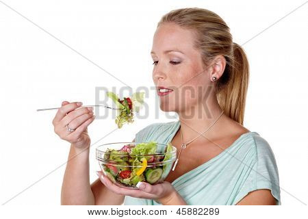 a young woman eating a fresh salad at lunch. healthy diet with vitamins.