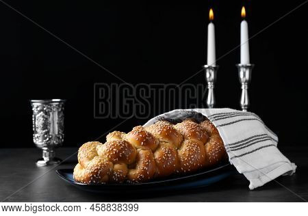 Homemade Braided Bread With Sesame Seeds, Goblet And Candles On Dark Grey Table. Traditional Shabbat