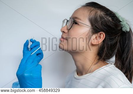 Close Up Of Doctor Hands Trying To Taking A Nasal Swab From Asian Woman For Testing Diagnosis Of Cov