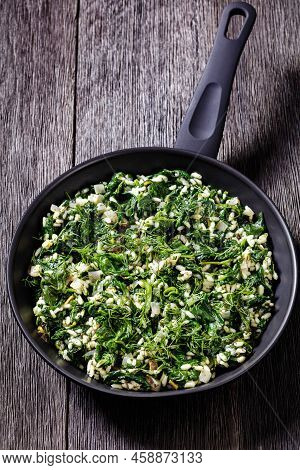 Spanakorizo, Greek Spinach And Rice Pilaf With Lemon, Dill, Spring Onion In Skillet On Dark Wooden T
