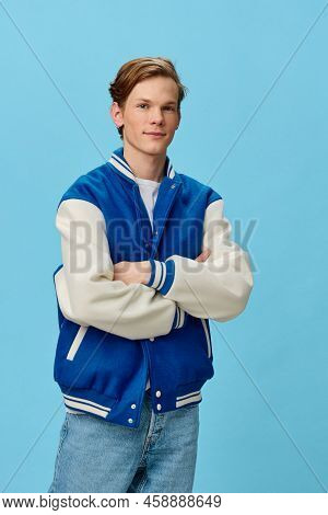 Beautiful, Happy An Attractive Young Man Student In A Trendy Bomber Jacket And Jeans Stands With His