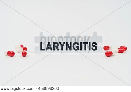 Medical Concept. On A White Surface Are Tablets And Puzzles With The Inscription - Laryngitis