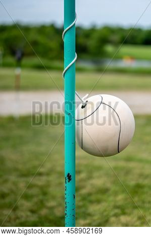 Tetherball Sitting Idle Next To The Pole In A Backyard.