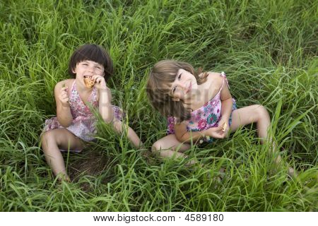 zwei Mädchen sitzen im Gras