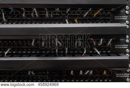 View Of Data Voice Patch Panel With Multiple Cables Connected. Communication And Networking Concept