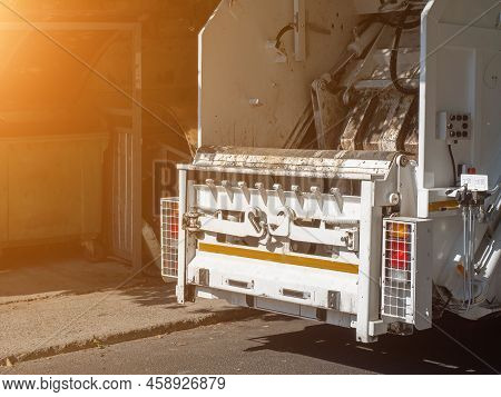 Garbage Truck Rear View. The Back Of A White Dirty Truck Taking Out The Garbage On A Sunny Day. Soft