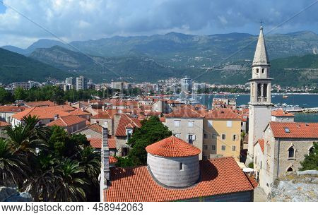 Montenegro, Budva. View Of The City And Mountains. Red Tiled Roofs.
