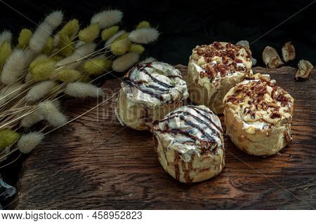 Two Cinnabon Chocobon (soft Chocolate Buns) Topped With Rich Cream Cheese Frosting And Two Caramel P