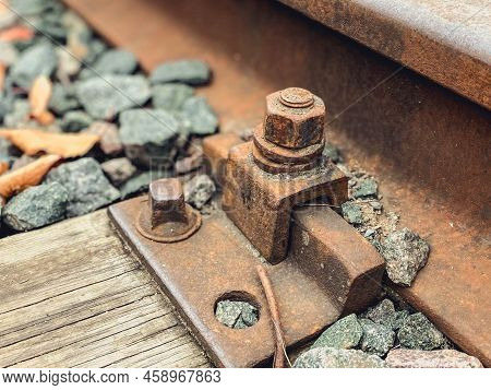 Old, Abandoned Railroad. The Rails Are Fixed With Strong Metal Bolts To The Ground. Rusty Structure 