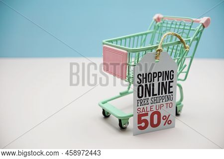 Shopping Online Sale 50% Text Message On Price Tax With Shoppint Trolley Cart On Blue And Pink Backg