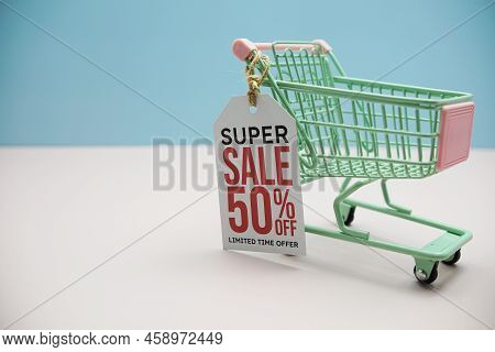 Super Sale 50% Off Text Message On Price Tax With Shoppint Trolley Cart On Blue Andp Pink Background