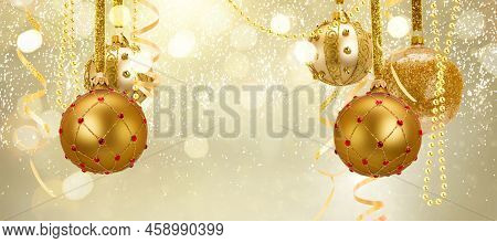 Golden Christmas Balls Garland And Evergreen Fir Tree On Glowing Golden Background