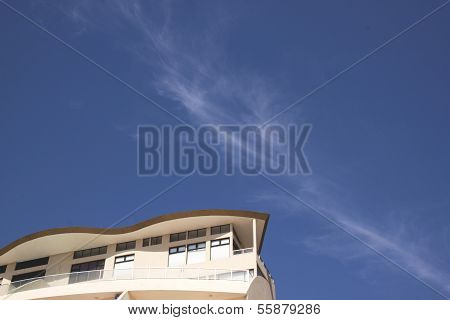 Underview Of Top Of Building Against Blue Sky And Clouds