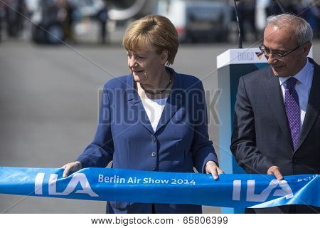 BERLIN, GERMANY - MAY 20, 2014: German Chancellor Angela Merkel (L) and Turkish Minister of transport Lutfi Elvan (R) open up the International aviation and space exhibition ILA.