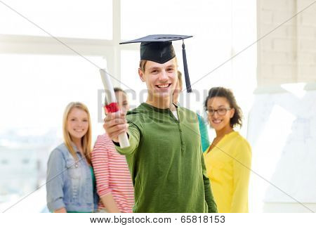 education and people concept - smiling male student with diploma and corner-cap and friends on the back