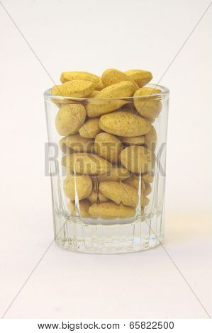Herb capsule spilling out of a cup