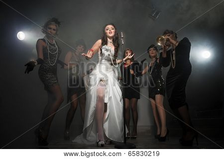 Young Singer bride with microphone and group of young women celebrating their friend`s forthcoming marriage