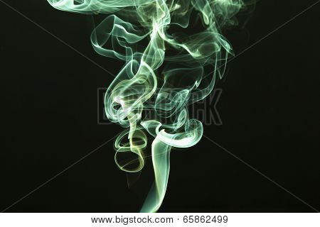 Green colored smoke on a black background.