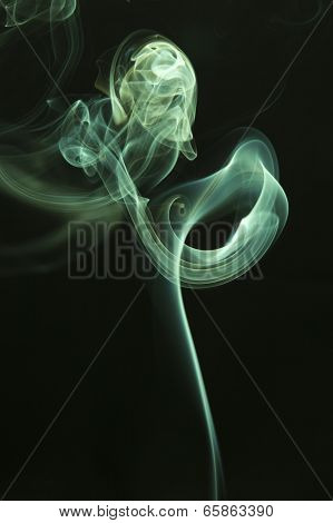 Green colored smoke on a black background.