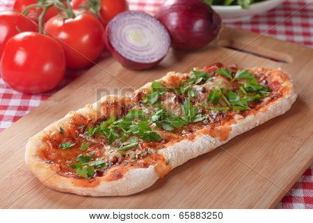 Plain homemade italian pizza with tomato sauce and herbs