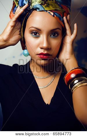 beauty bright african woman with creative make up, shawl on head like cubian woman