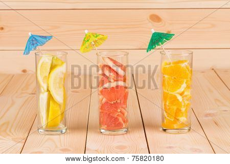 Lemon orange and grapefruit in glass on table.