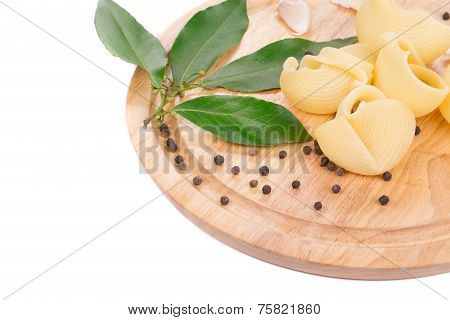Italian pasta shells on a wood plate.