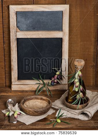 Vintage Table Setting With Olives And  And Antique Blackboard On The Wooden Background