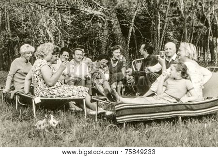 USTRONIE, POLAND, CIRCA SIXTIES: Vintage photo of group of people parting in garden