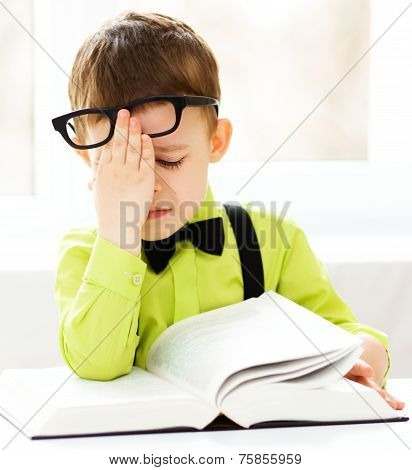 Little Boy Is Reading A Book