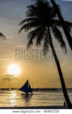 Sailing Boat Under Sail And Silhouette Of People Against A Beautiful Sunset