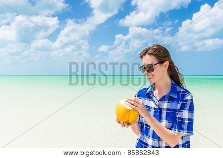 Young Cheerful Woman With Coconut Against Turquoise Sea At Tropical Sandy Beach During Caribbean Vac