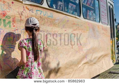 Rear View Of Cute Little Girl Drawing A Picture On The Wall