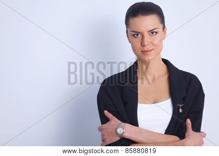 A young woman standing, isolated on graybackground