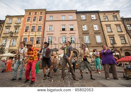 KRAKOW, POLAND - JUL 12, 2015: Participants at the annually (July 9-12) 28th International Festival of Street Theatres - Orchestre International du Vetex (Belgium/France) in the Main Square of Krakow.