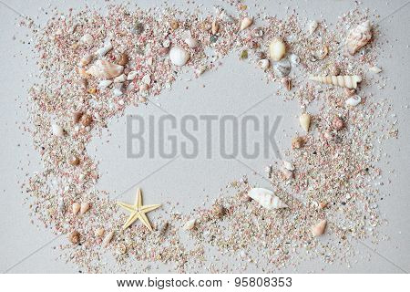 Sea shells and pink sand with a starfish on a paper background with empty space for text