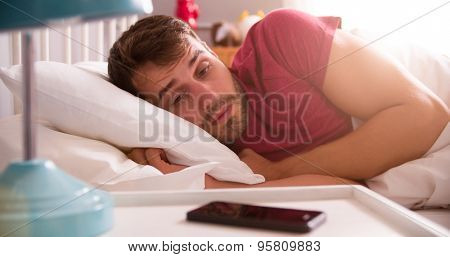 Man In Bed Woken By Alarm On Mobile Phone
