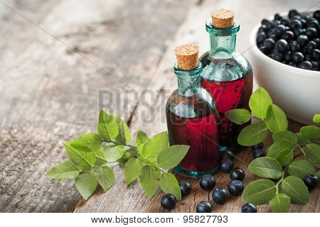Bottles Of Tincture Or Cosmetic Product And Bowl With  Blueberries On Wooden Table.