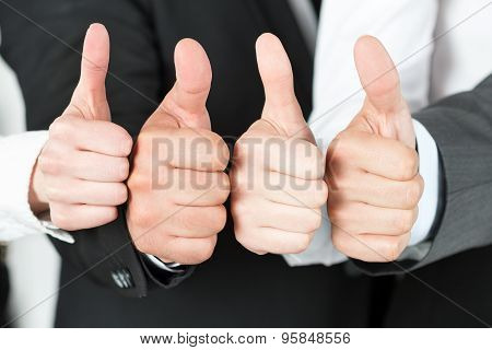 Business Team Pointing Up Their Thumbs